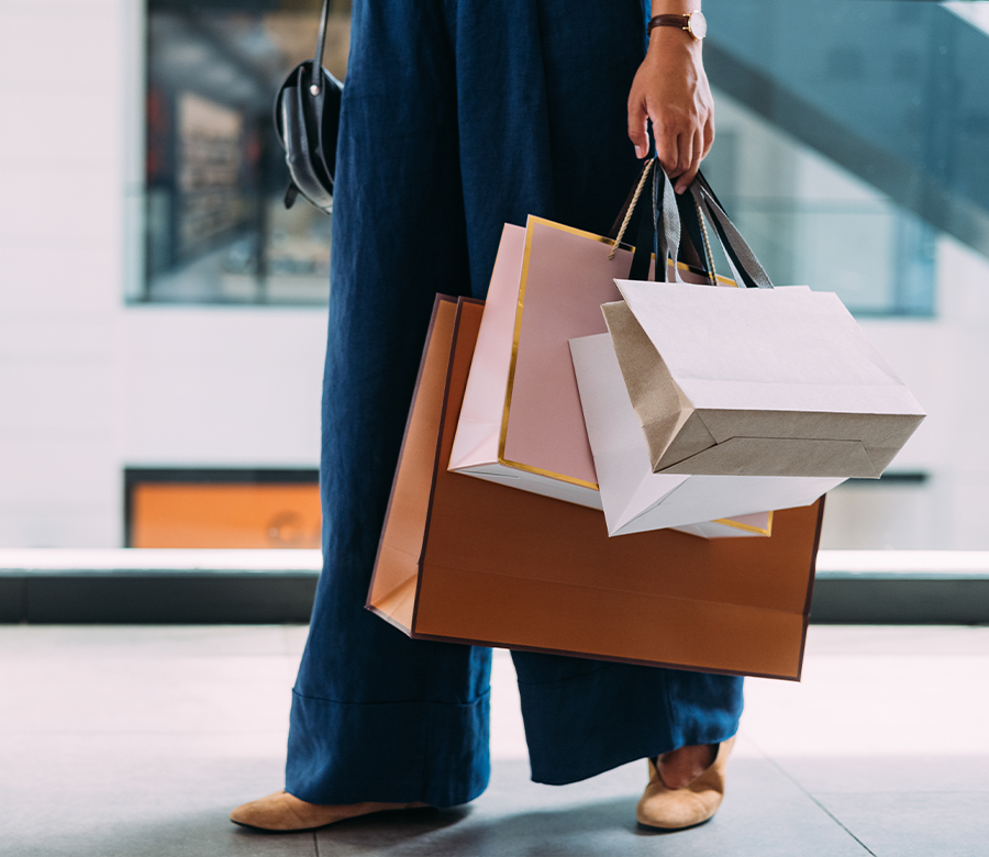 Personne tenant plusieurs sacs dans un centre commercial.